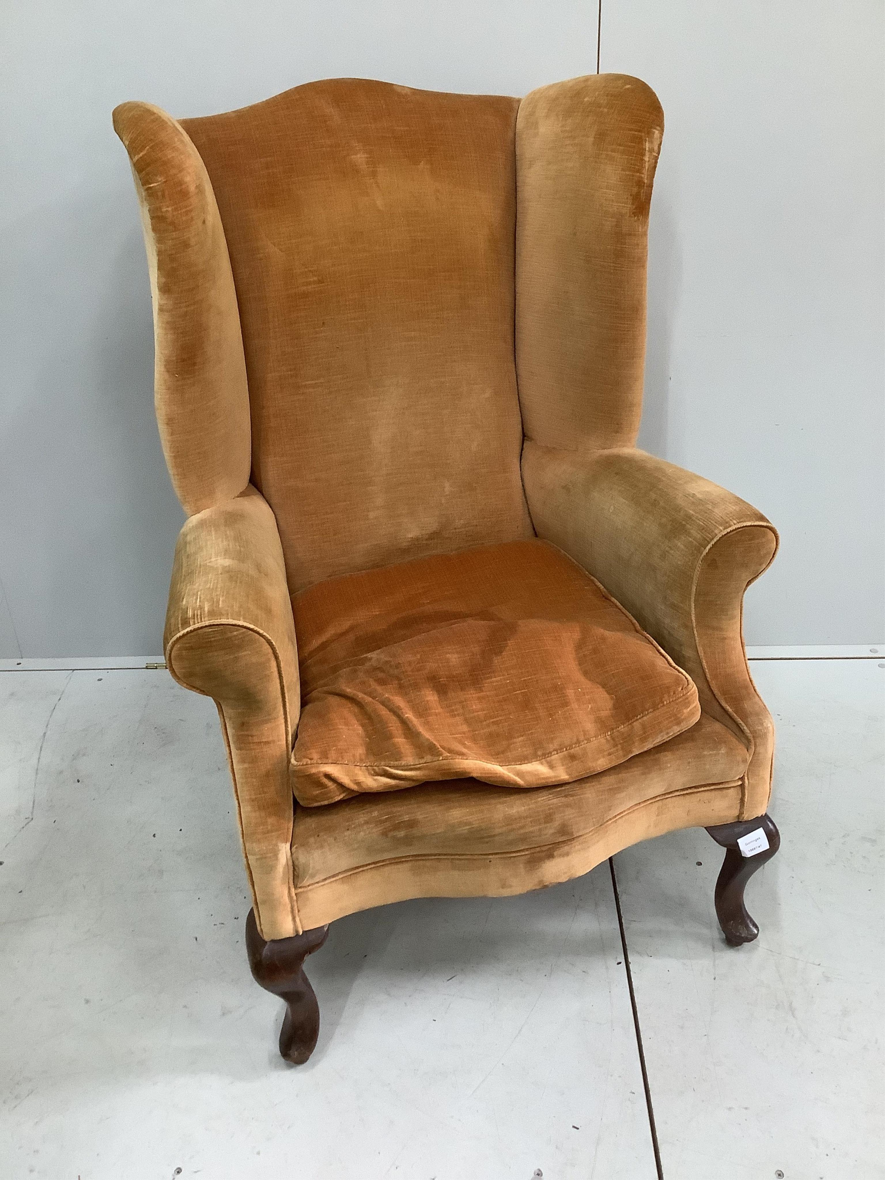 An early 20th century upholstered wing armchair, width 81cm, depth 72cm, height 110cm. Condition - fair